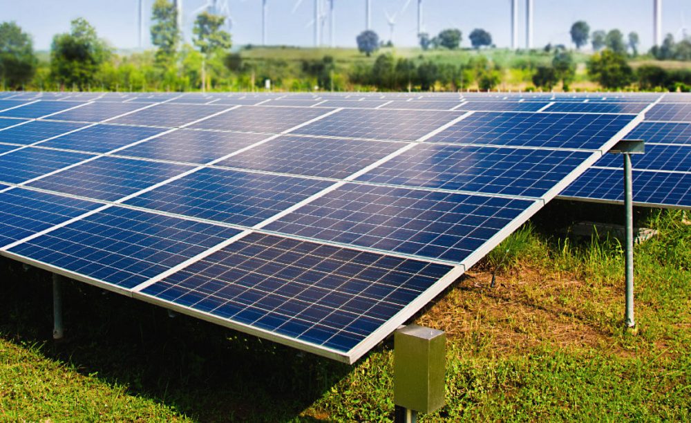 solar-panel-with-wind-turbines-against-mountains-sky